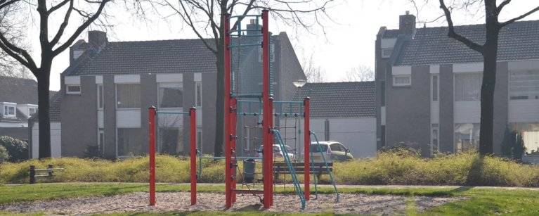 Foto van een straat in de buurt Koolhof, Deurne. Een speeltuintje met op de achtergrond een paar huizen.