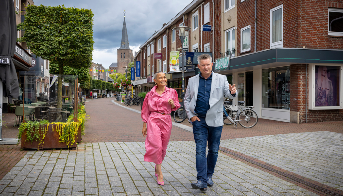 Twee medewerkers lopen samen door een straat in het centrum van Deurne.