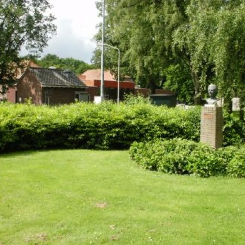 Borstbeeld Juliana, met op achtergrond struiken, bomen en een huis