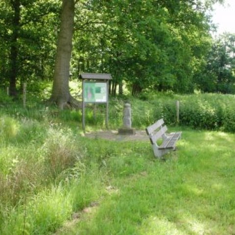 Kunstwerk Grenspaal Peellimieten, bij een informatiebord en een zitbankje