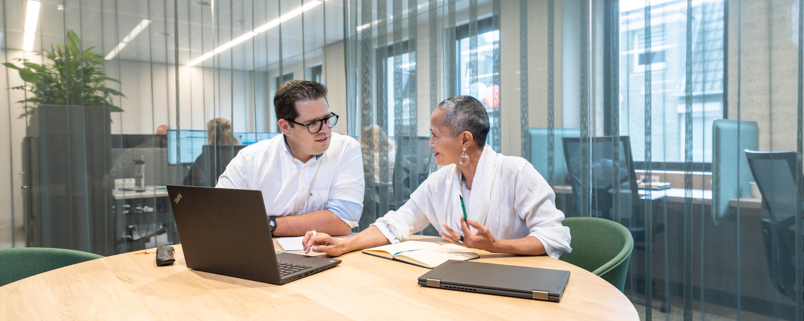 Collega’s zitten gesprekken te voeren in verschillende ruimtes.