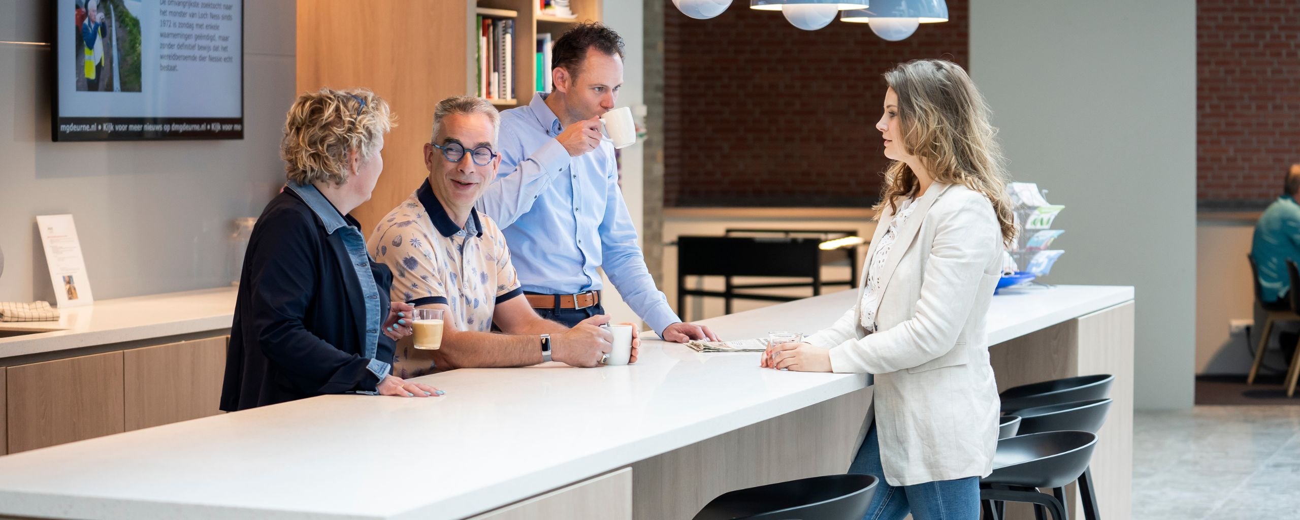 4 medewerkers gemeente Deurne in overleg in de koffieruimte
