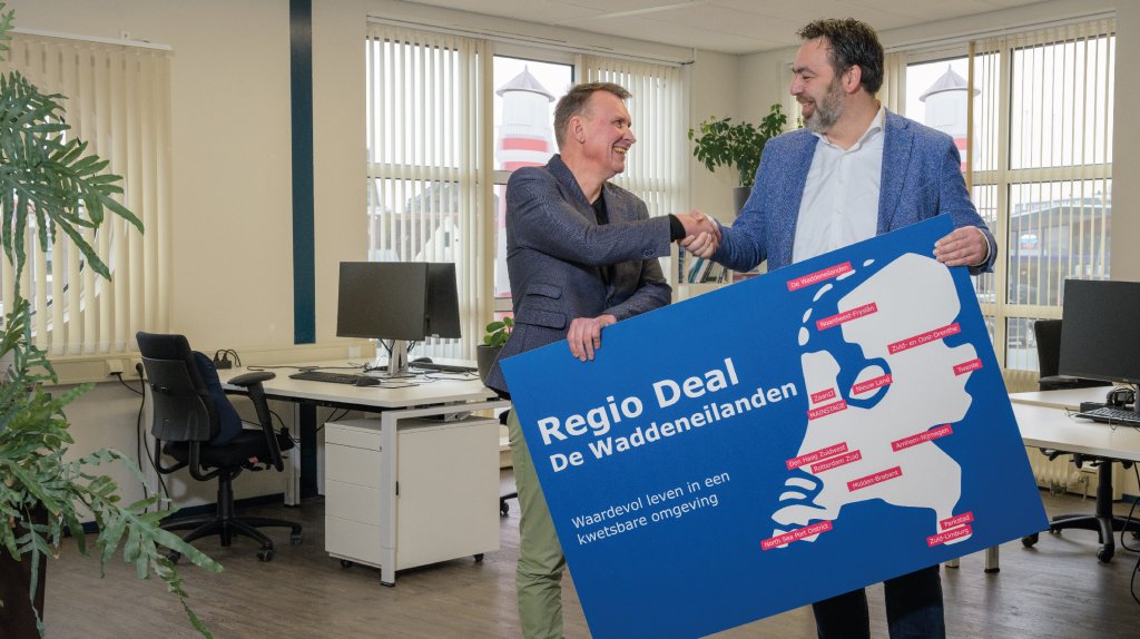 Michiel Schrier, burgemeester van Vlieland en voorzitter van de stuurgroep van Regio Deal De Waddeneilanden en Arjen Droog van Planbureau Fryslân bezegelen samenwerking voor lerende evaluatie met handdruk. 