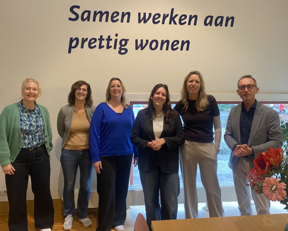 Zes personen staand, lachend, 5 vrouwen en 1 man