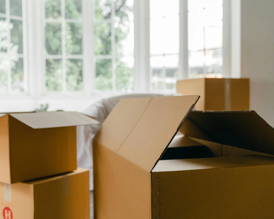 Verhuisdozen met op achtergrond ruitramen, buitenlicht