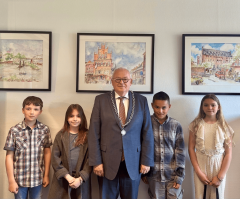 Burgemeester Hofland in het midden met aan beide zijden twee kinderen