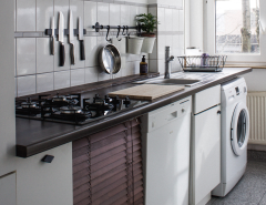 Keukenmet fornuis, messen, witgoed en raam met invallend zonlicht