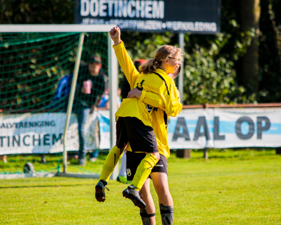 Twee voetbalspelers juigen op het voetbalveld