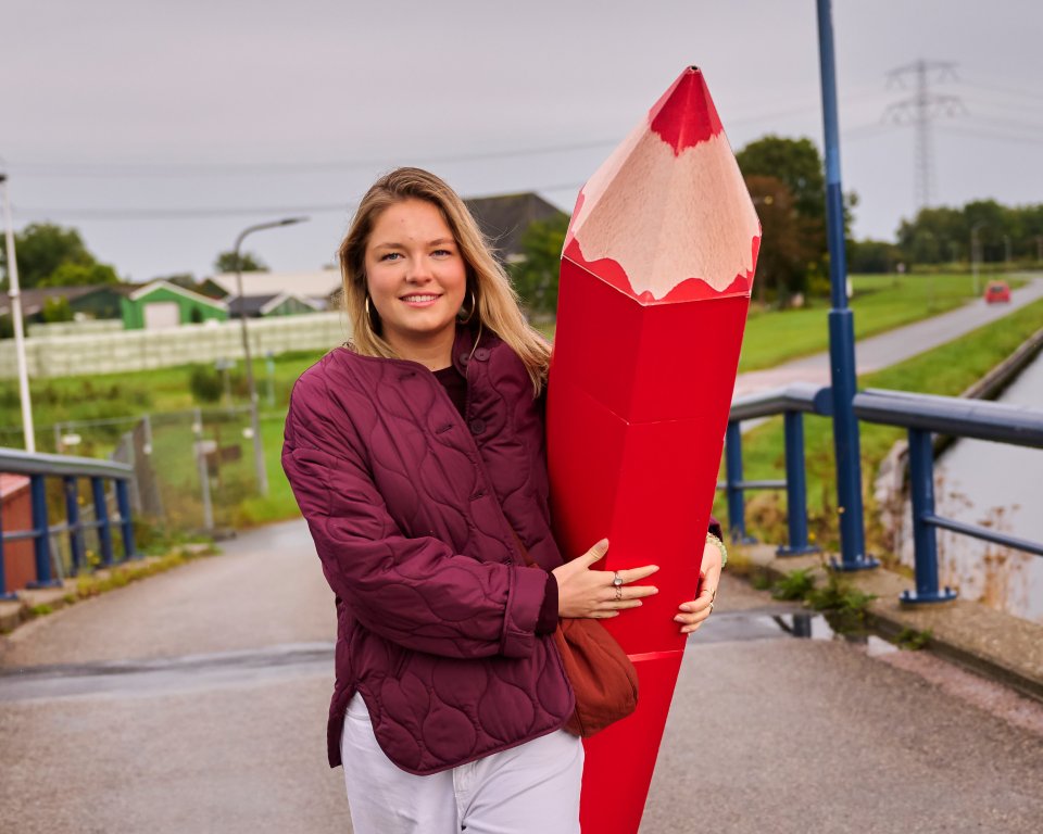 Vrouw met een rood potlood in haar armen