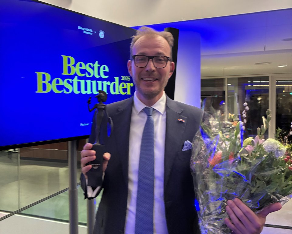 burgemeester Boumans staat lachend met zijn gewonnen prijs op de foto