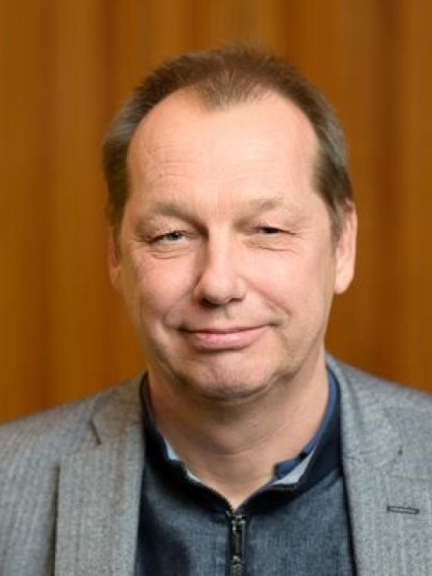 Ruud Schuurman. Man met kort geknipt haar. Lachend met de mond dicht.