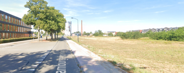 De Hamburgerbroeklaan met links appartementen en rechts groen en op de achtergrond de stad