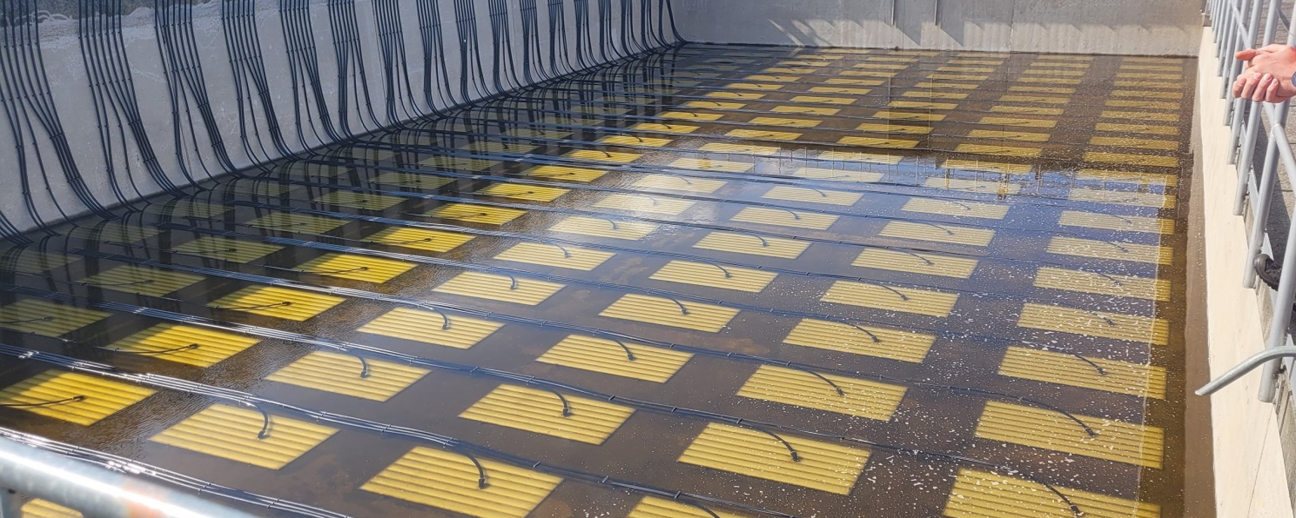In een betonnen bak liggen beluchtingsplaten op de grond. 