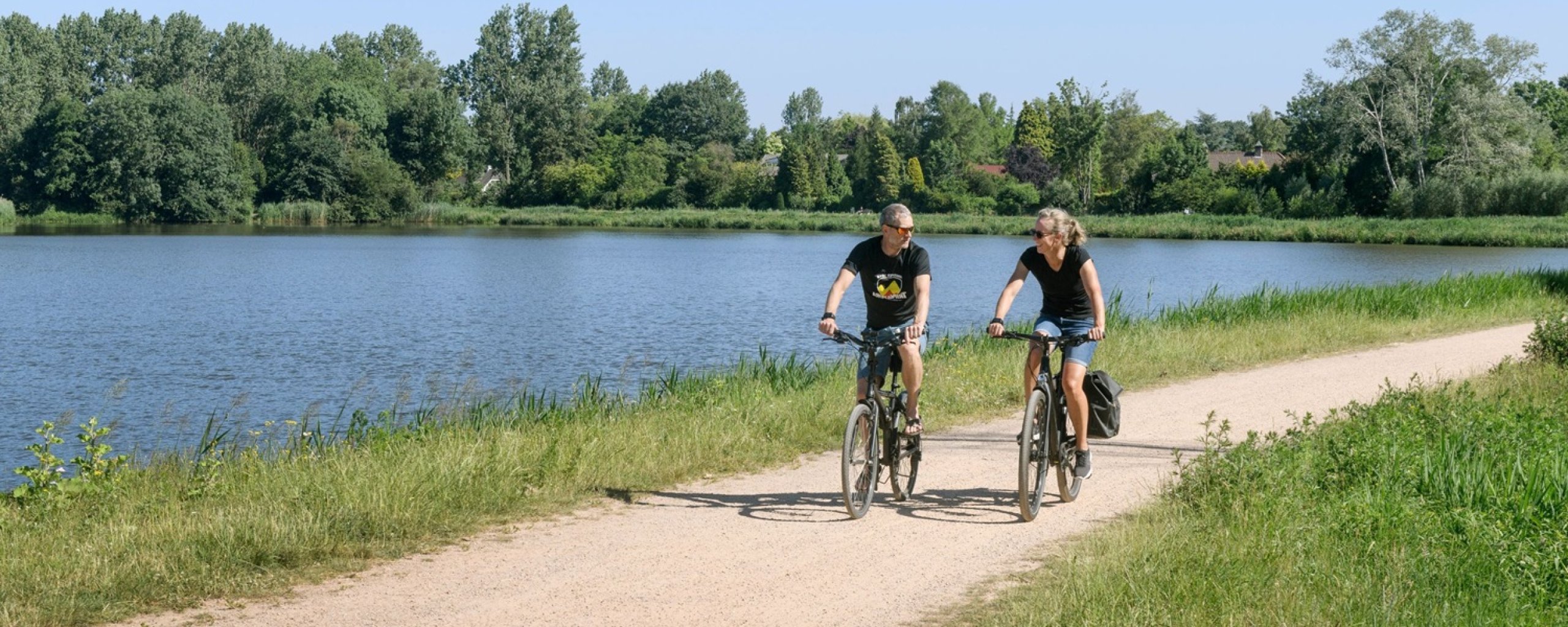Fietsers fietsen langs het water bij de Klotputten