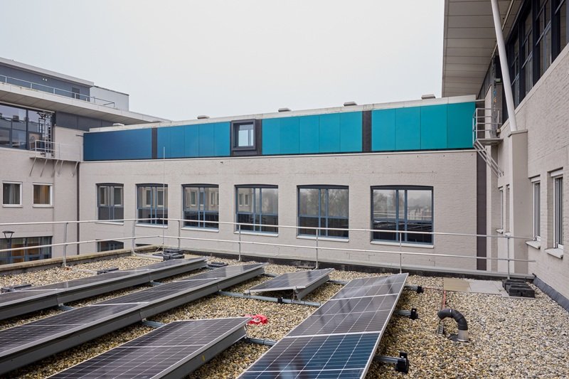 Zonnepanelen op het dak van Waterschap De Dommel met de corridor met speciale zonnepanelen op de achtergrond