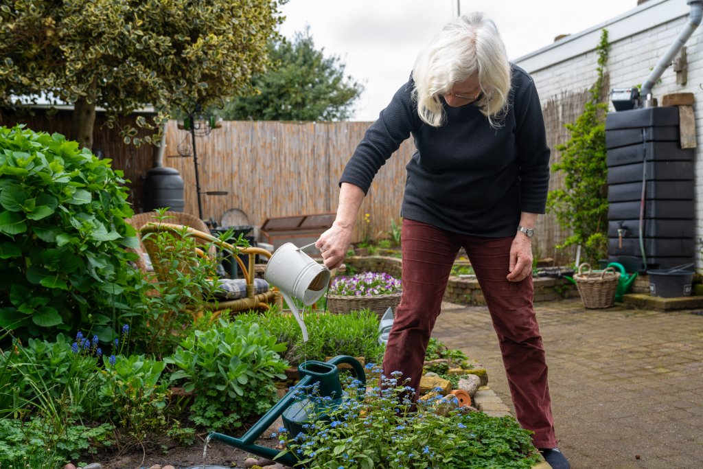 Marijke met gieter in tuin