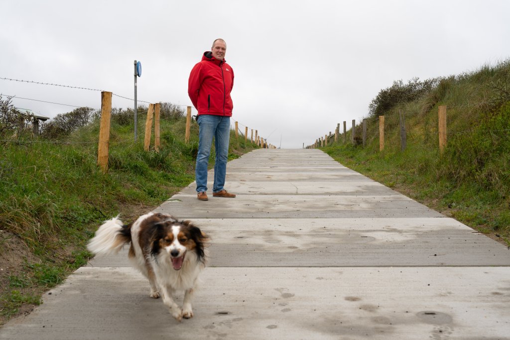 Marc loopt met zijn hondje over de betontegels
