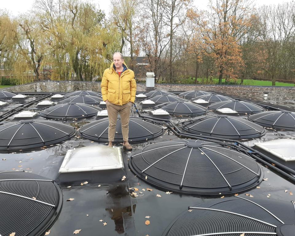 Voorzitter Elmar van Krimpen op het dak van een zwembad in Nederland waar al zonnecollectoren liggen.