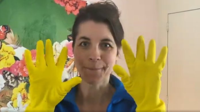 Vrouw met gele poetshandschoenen aan