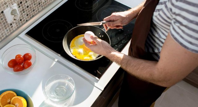 Koken op een inductieplaat, er wordt een eitje gebakken in de pan