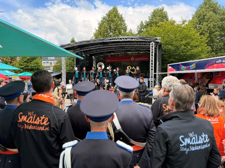 Publiek kijkt naar optreden van muziekkorps