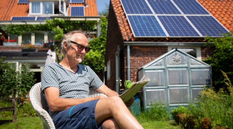 Man zit in zijn tuin in de zon de krant te lezen