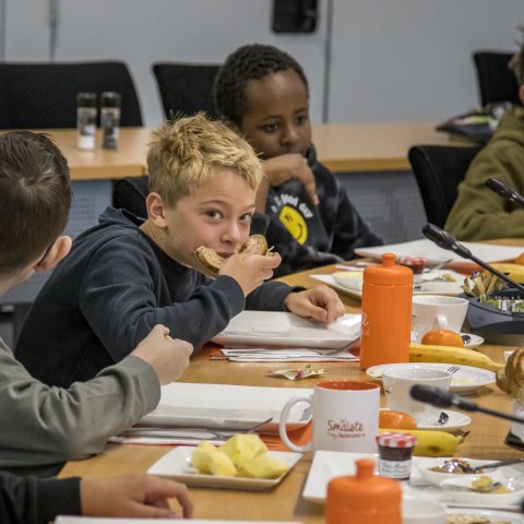 Kinderen aan het ontbijt in de raadzaal