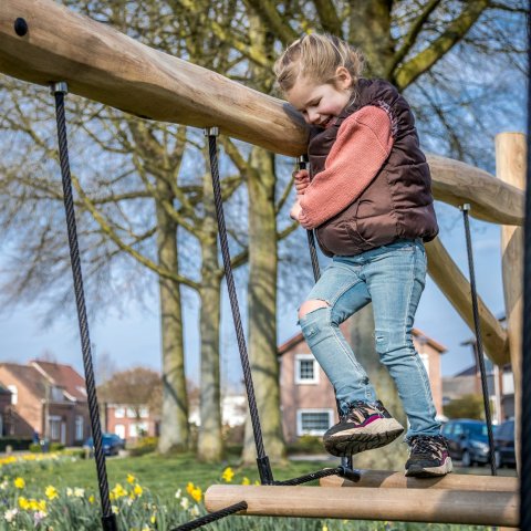 Een meisje loopt op een klimrek