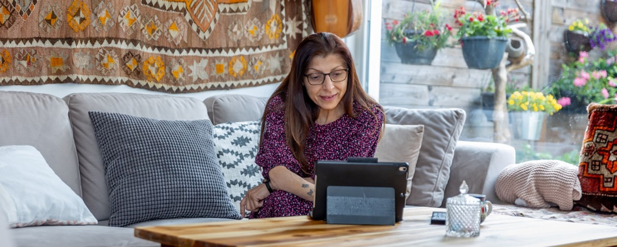 Vrouw zit achter haar laptop in de woonkamer