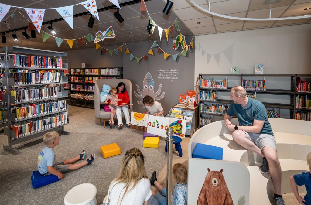 Wethouder Inge Minkenberg leest voor aan jonge kinderen in de bieb