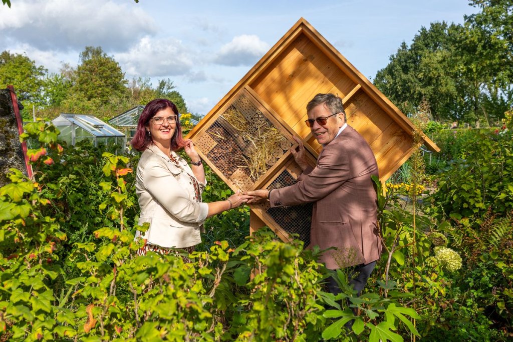 Voorzitter volkstuin en wethouder Hub Meuwissen plaatsen insectenhotel