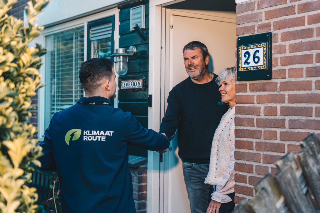 Bewoners van een huis verwelkomen aan de voordeur een medewerker van Klimaatroute.