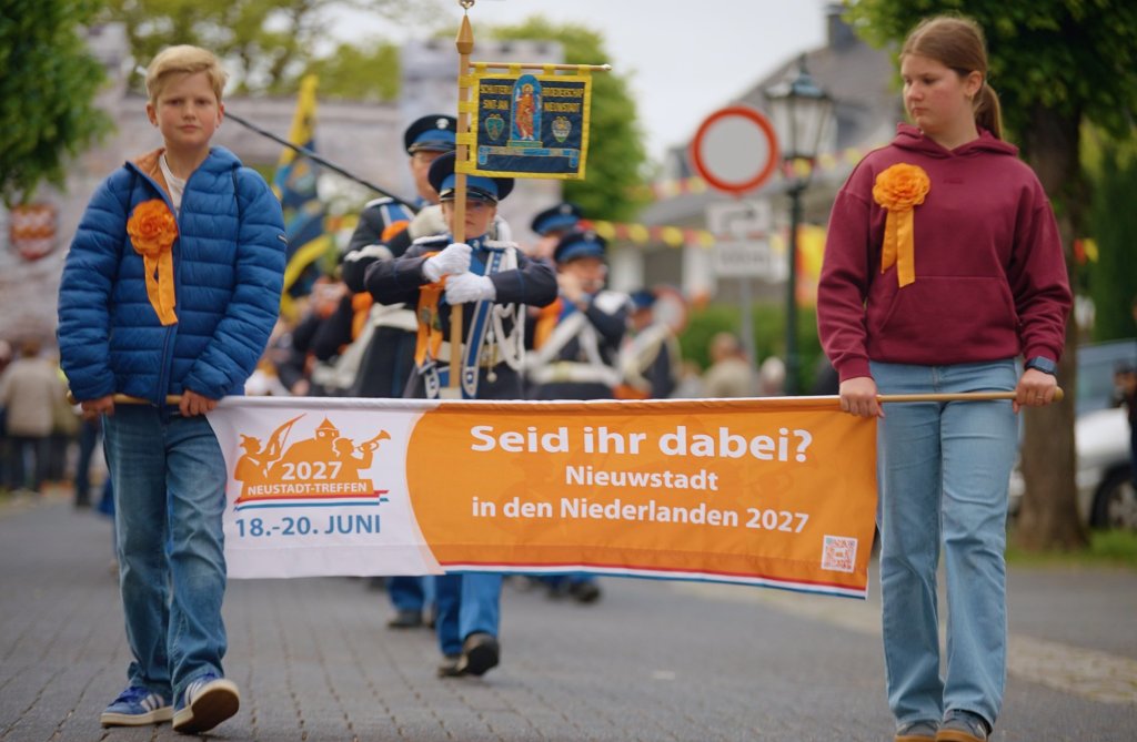 Twee kinderen dragen vaandel in de optocht van het Neustadt Treffen 2026 in Bergneustadt in Duitsland