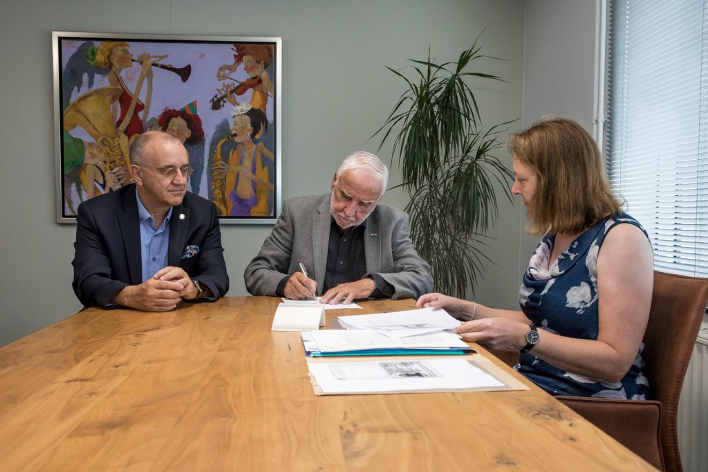 Cees van Prooijen zet handtekening in het bijzijn van onder anderen Burgemeester Jos Hessels