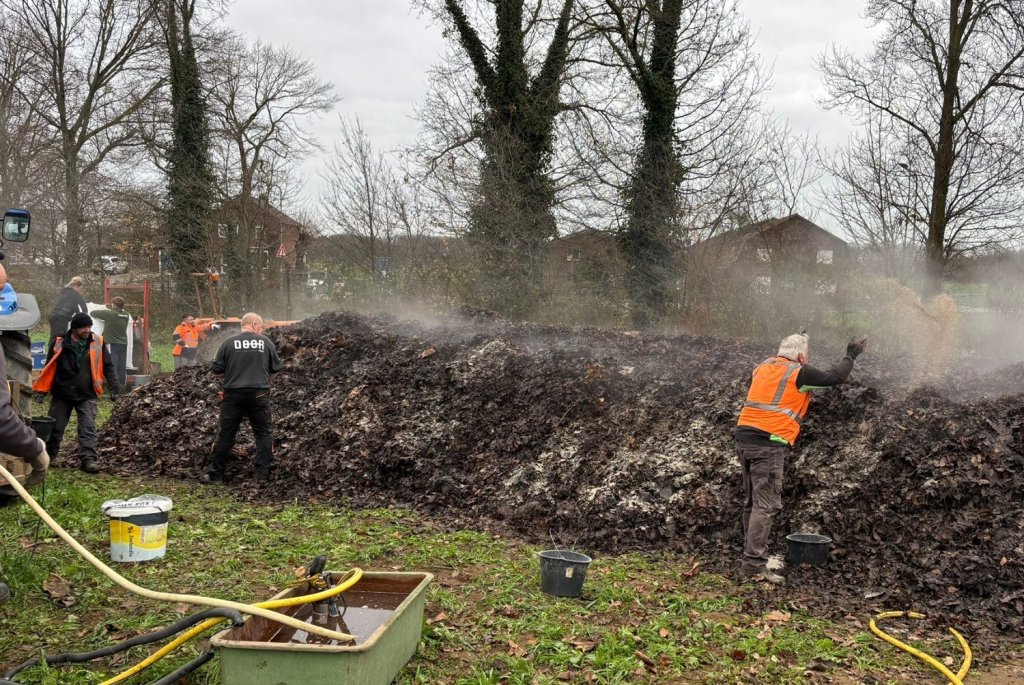 Medewerkers aan het werk bij de berg bokashi