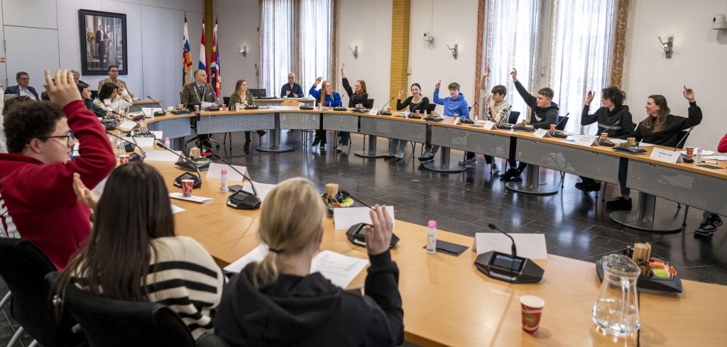 leerlingen debatteren in collegezaal