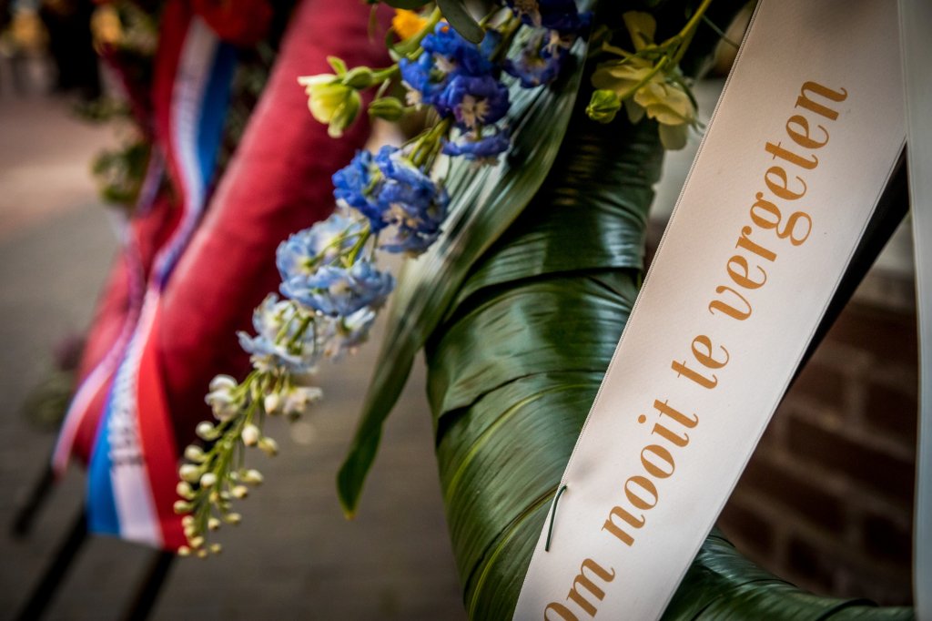 Herdenkingskrans met linttekst: 'Om nooit te vergeten'