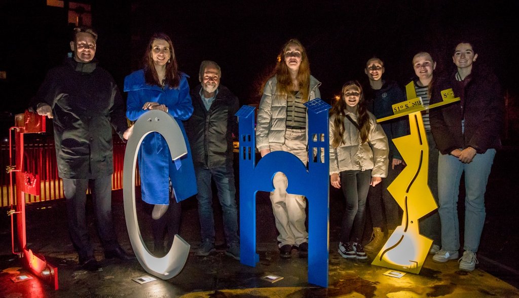 Wethouders Geert Frische en Kim Leurs, kunstenaar Lei Hannen en leerlingen van het Connect College staan bij het kunstwerk