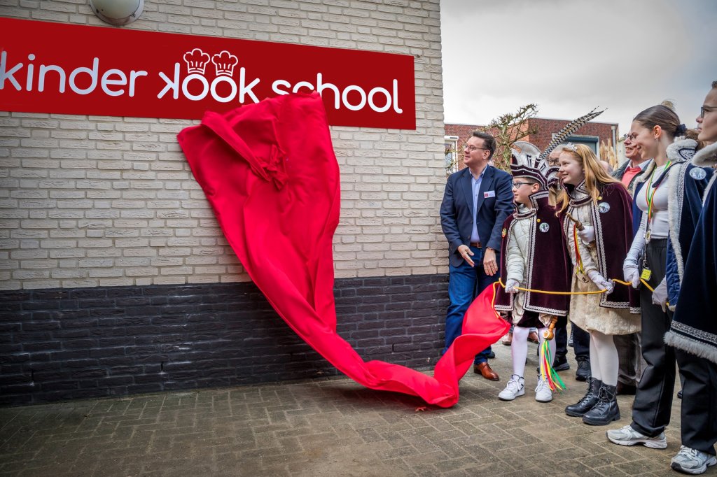 Wethouder Geert Frische verricht samen met twee oud-leerlingen de openingshandeling