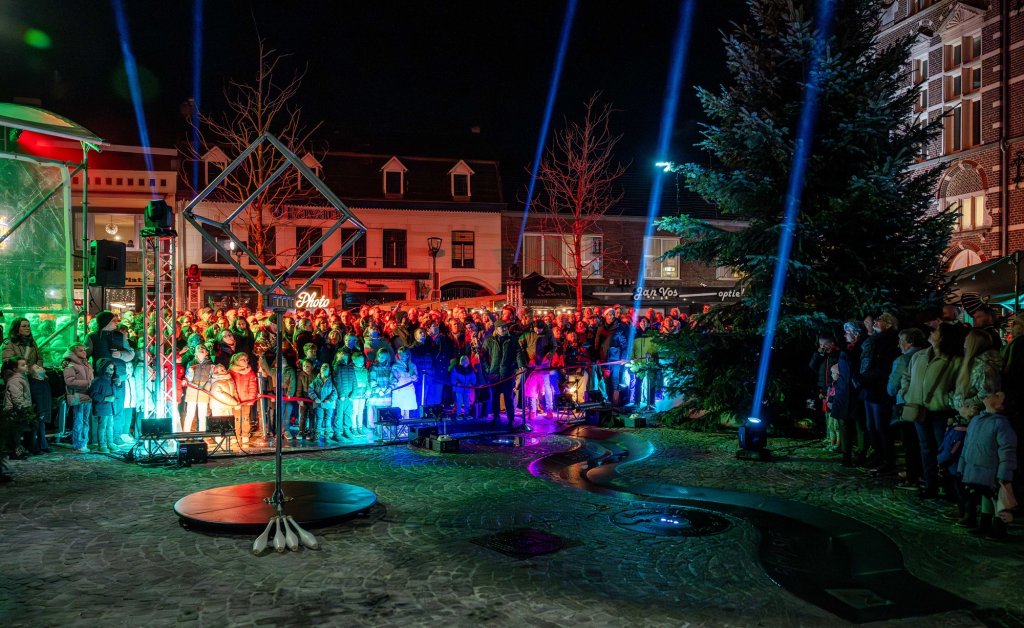 Toeschouwers op de Plats in gekleurd licht wachtend op het begin van de show