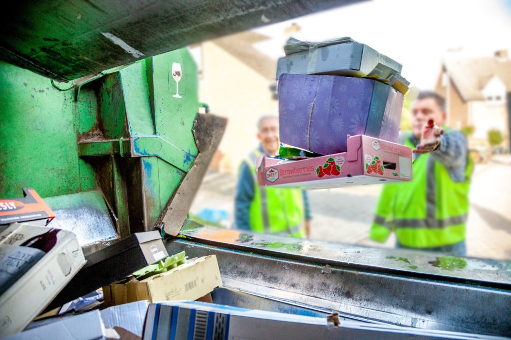 Oud papier wordt in de vuilniswagen gegooid