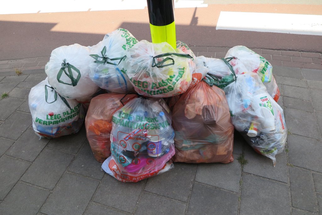Enkele PDM-zakken op de stoep om een lantaarnpaal.