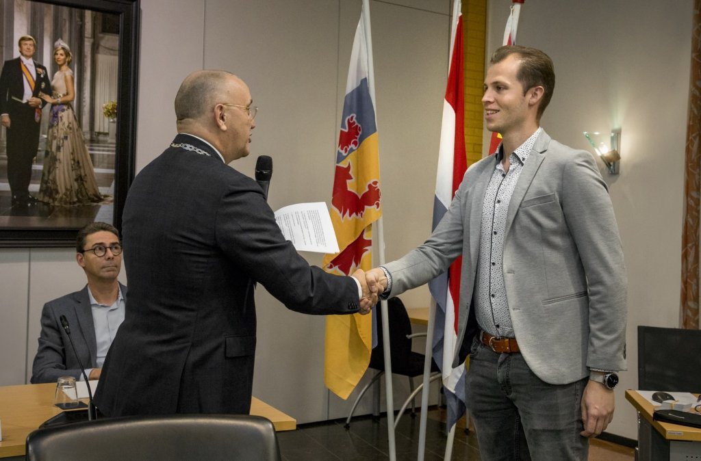 Burgemeester Jos Hessels schudt nieuw raadslid Robin Peeters de hand