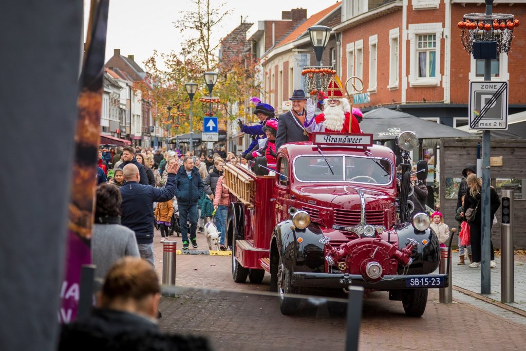 Sinterklaas, de pieten en burgemeester Hessels rijden op een oude brandweerauto door het centrum van Echt