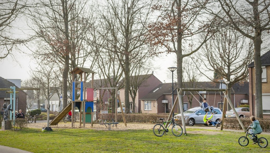 Kinderen spelen in een speeltuin in een woonwijk