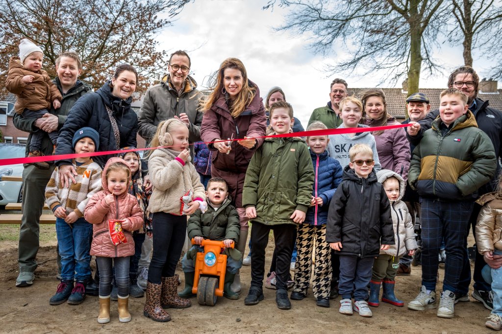Wethouder Kim Leurs knipt in het bijzijn van kinderen en buurtbewoners een rood lint door