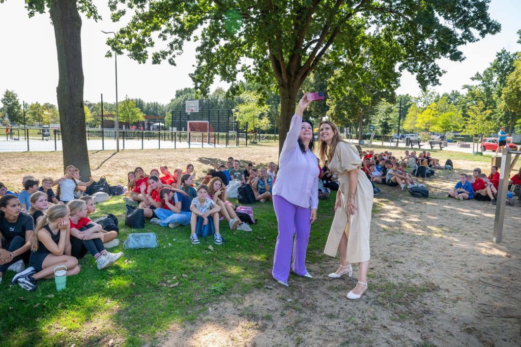 Wethouders Inge Minkenberg en Kim Leurs maken een selfie omringt door brugklassers