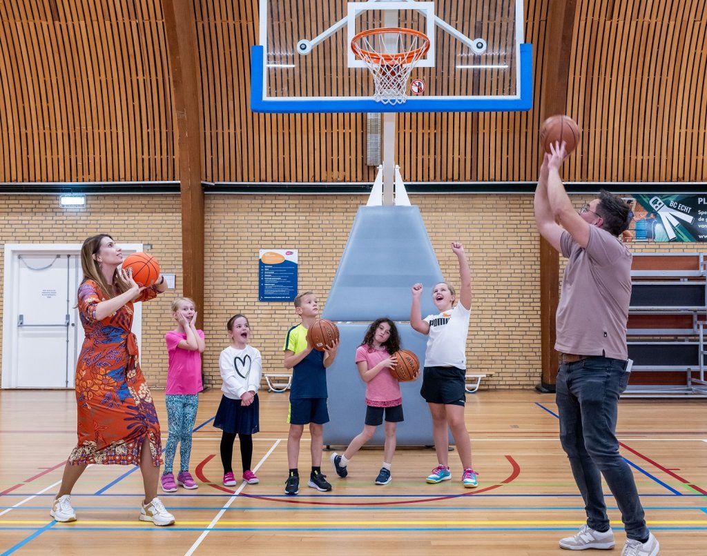 Wethouder Kim Leurs gooit samen met basisschool kinderen een basketbal