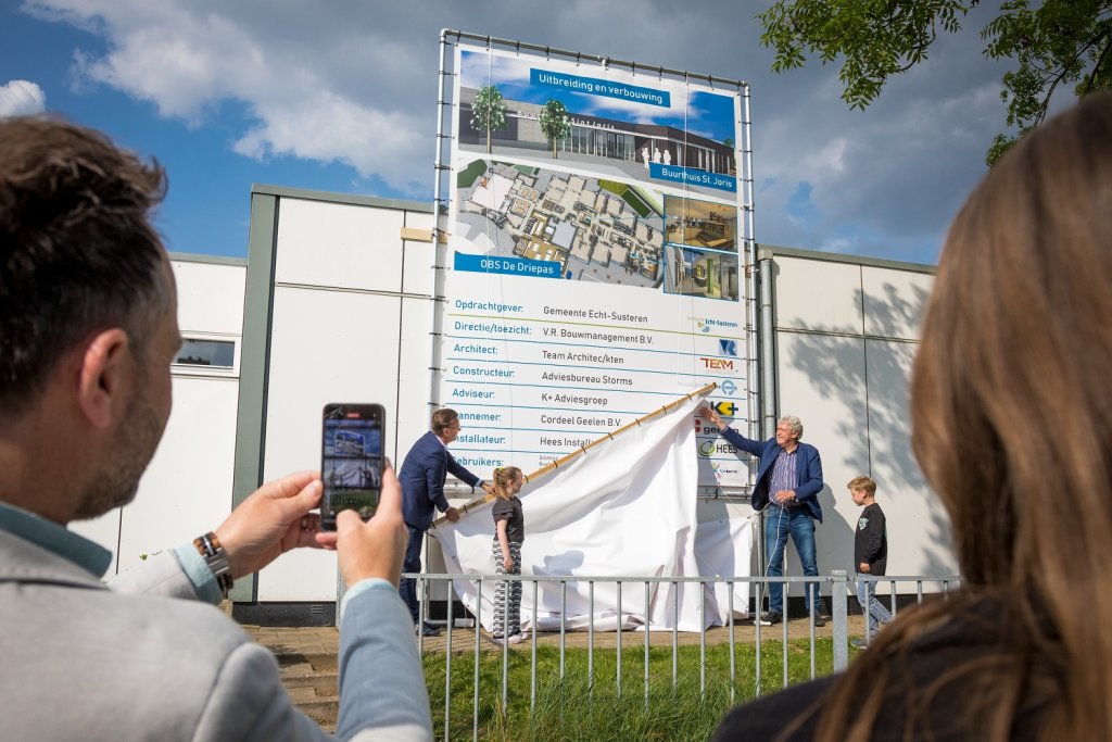Wethouders Peter Pustjens en Geert Frische onthullen een publicatie-bouwbord