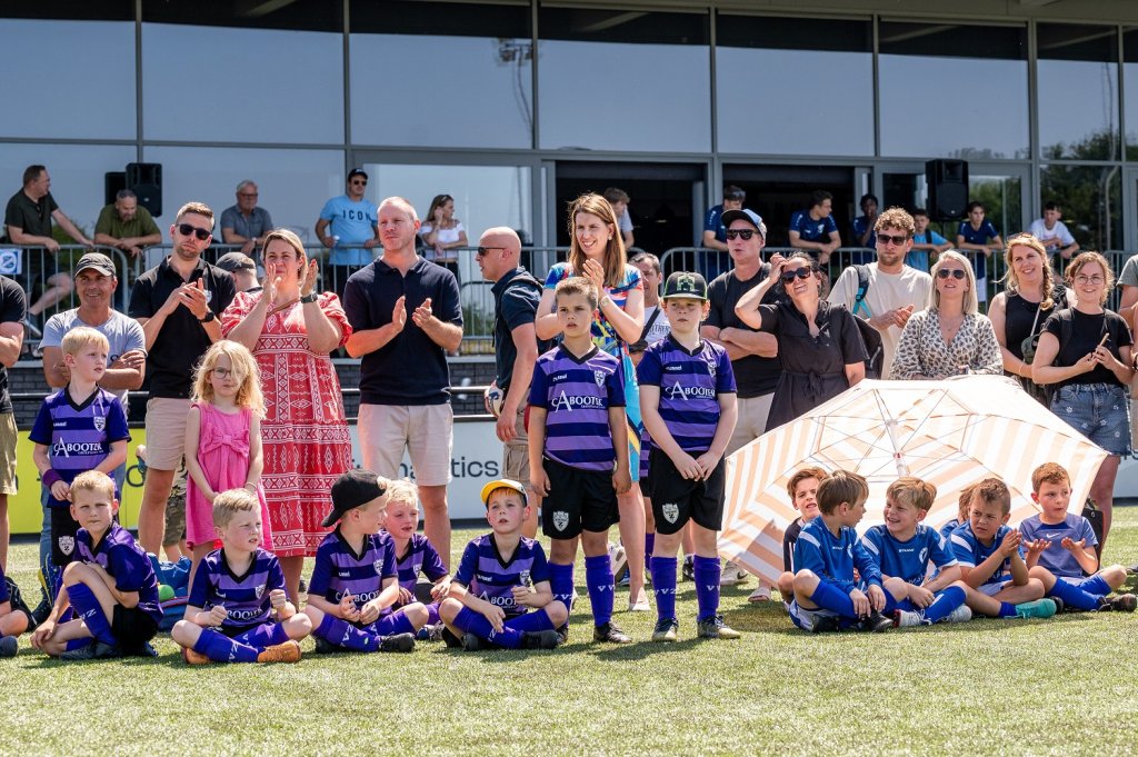 Wethouder Kim Leurs, ouders en spelertjes langs de kant van het voetbalveld